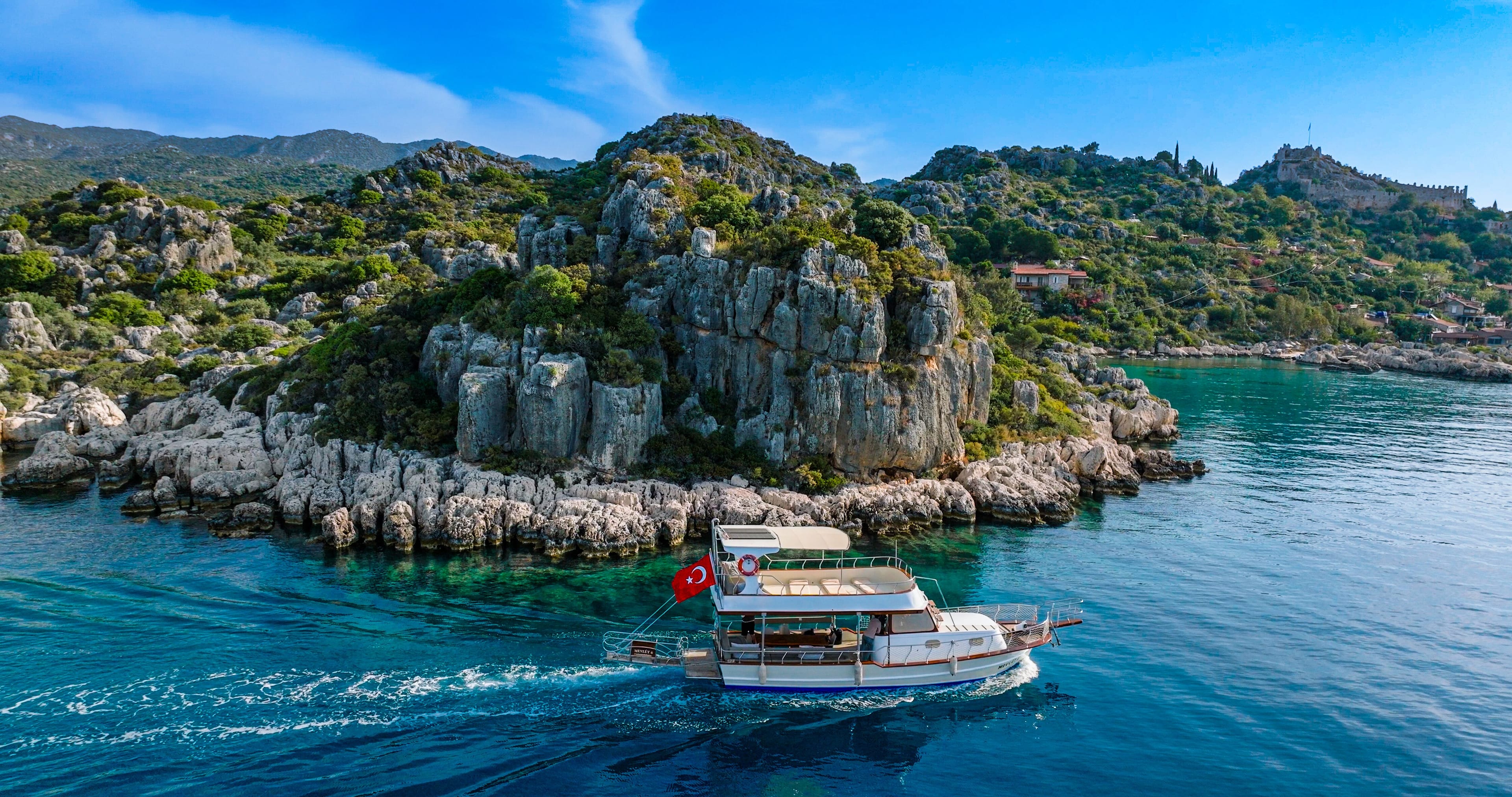 Boat cruising past the cliffs and castle of Kaleköy, Antalya